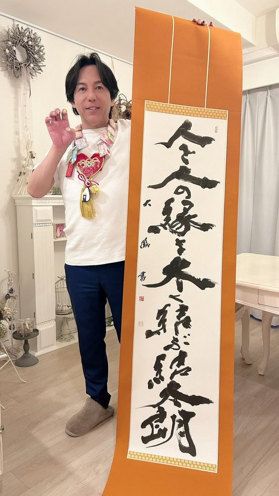 「人と人の縁を結ぶ」と書かれた掛け軸と縁結び士 結太朗